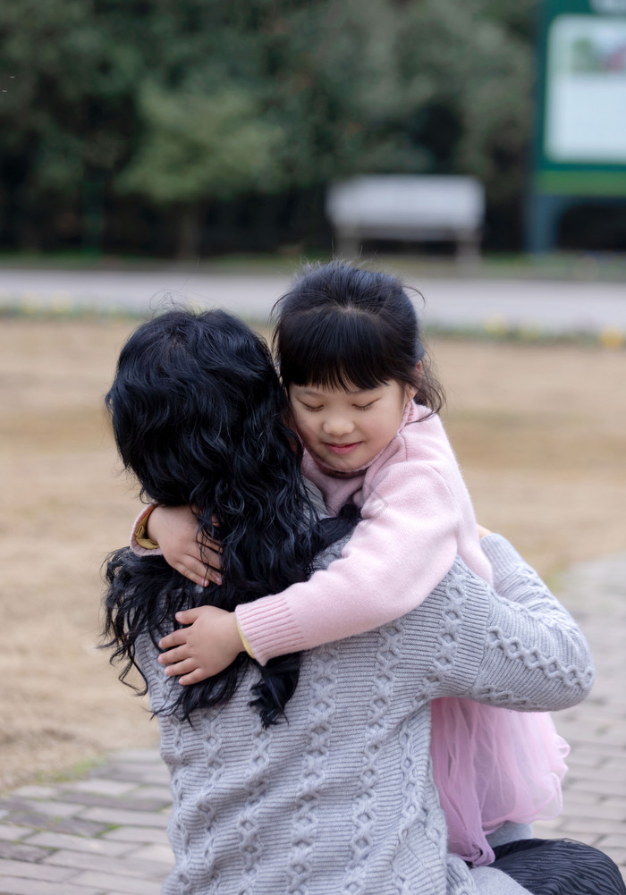 和妈妈温馨拥抱在一起的小女孩图片