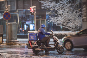 夜晚辛勤送外卖的外卖小哥背影摄影图片