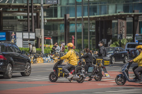 城市中奔波送餐的外卖小哥的摄影图片