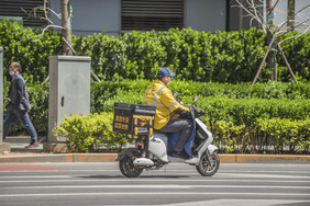 城市中奔波送餐的外卖小哥摄影图片