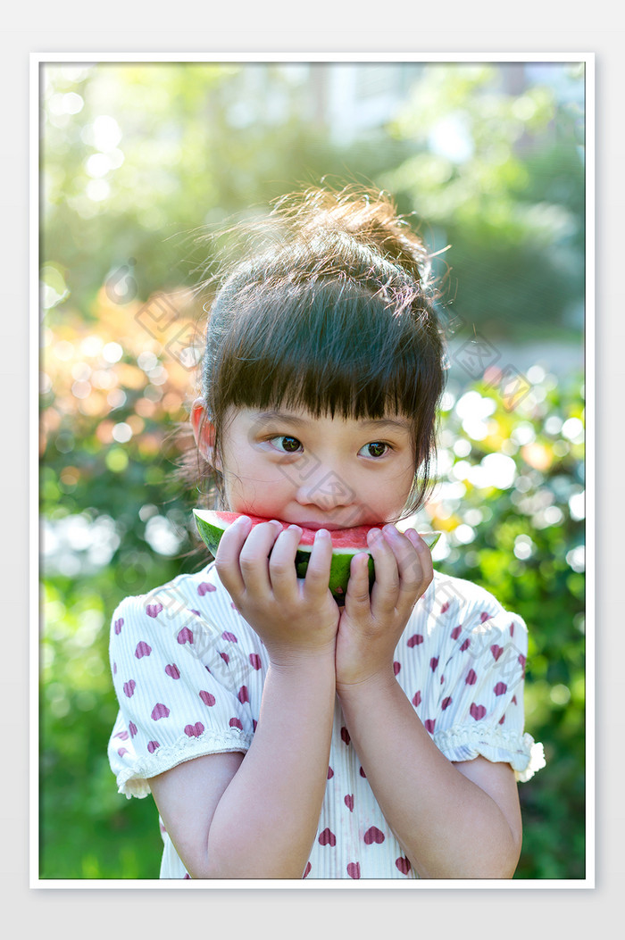 阳光下吃西瓜的可爱小女孩