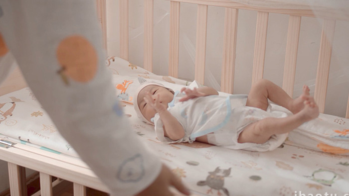 人物妈妈把婴儿放回婴儿床上4K视频素材