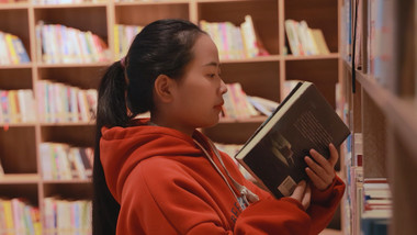 人物形象女孩在图书馆拿书阅读
