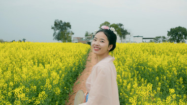 春季汉服美女在菜花田背影实拍