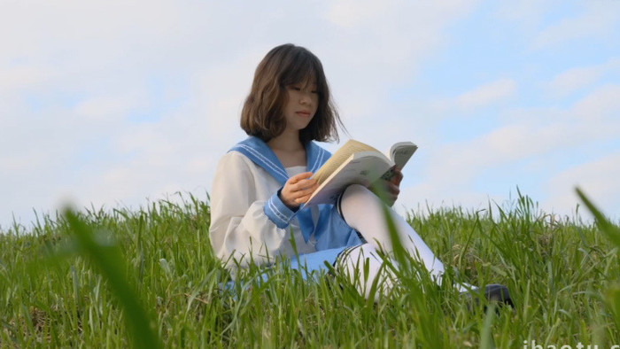 春天女孩在草地上看书实拍视频