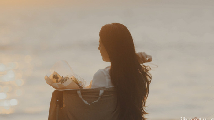 海边等待日落的年轻女性背影实拍