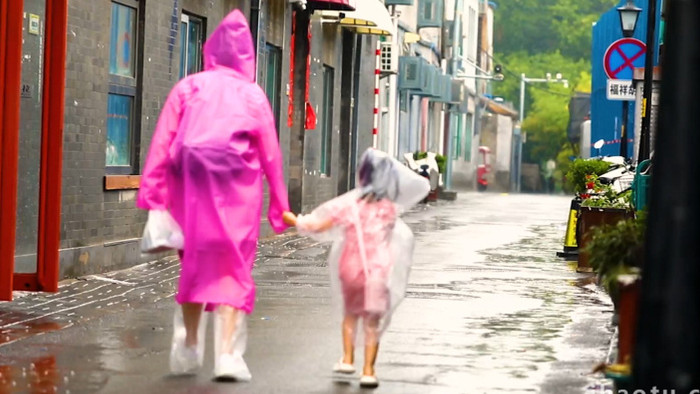 父母牵手孩子雨中漫步空镜实拍