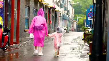 父母牵手孩子雨中漫步空镜实拍