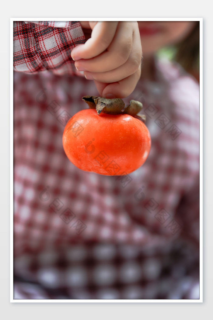 可爱的孩子拿着柿子