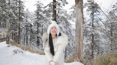 东方人像女孩雪地开心打雪仗实拍