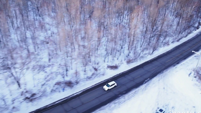 冬季雪地森林道路行驶的汽车航拍