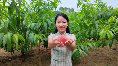 女孩手捧桃子对着镜头微笑实拍