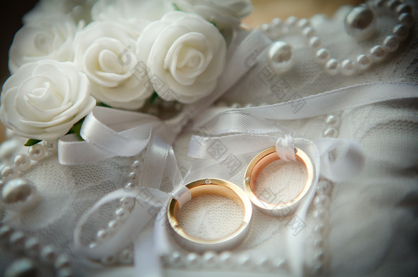 白花在背景中的两个结婚戒指。.