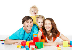 幸福的家庭四人。微笑的父母孩子玩玩具积木