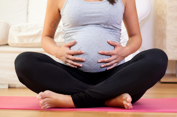 怀孕的女人坐在运动垫