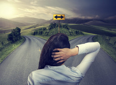 business woman in front of two roads thinking deciding