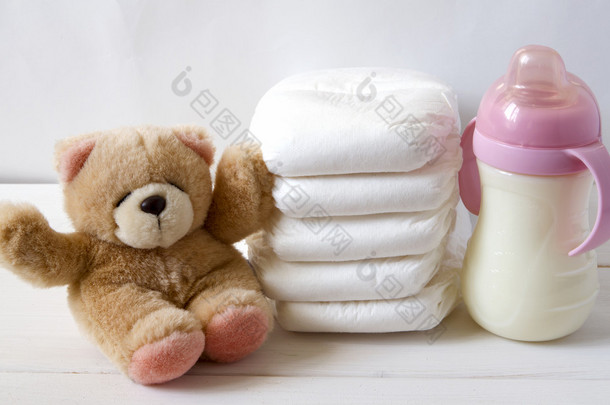 新出生的孩子堆栈的尿布，tebby 熊玩具和婴儿奶瓶