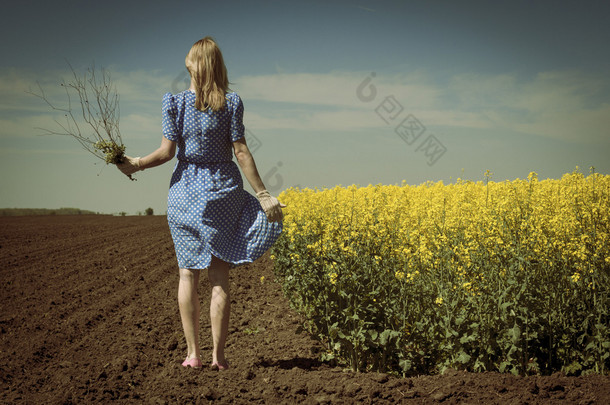 孤独的高加索女人在油菜领域保持<strong>流量</strong>后视图