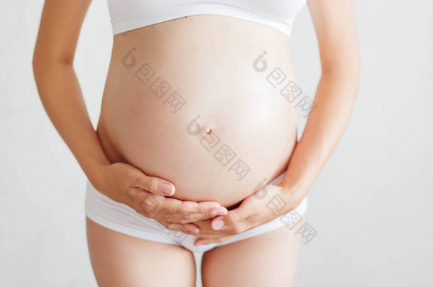 在白色内裤的孕妇。年轻女人怀孕了.