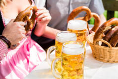 啤酒和椒盐卷饼在德国啤酒花园的眼镜