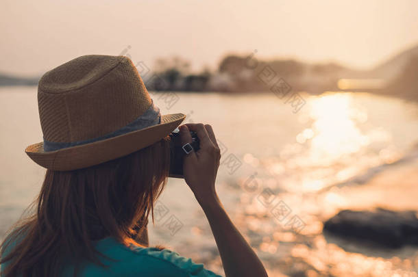 年轻女人旅行拍照海滩，美丽的太阳