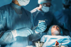 外科医生在手术室清理手术镊子的图像
