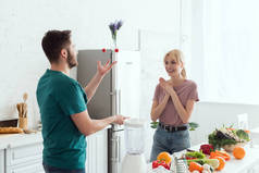 素食男友杂耍樱桃西红柿为快乐的女朋友在厨房