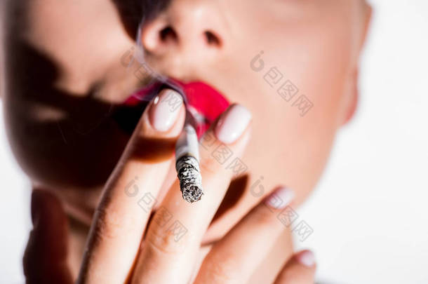 <strong>女性</strong>吸烟香烟的裁剪图像白色