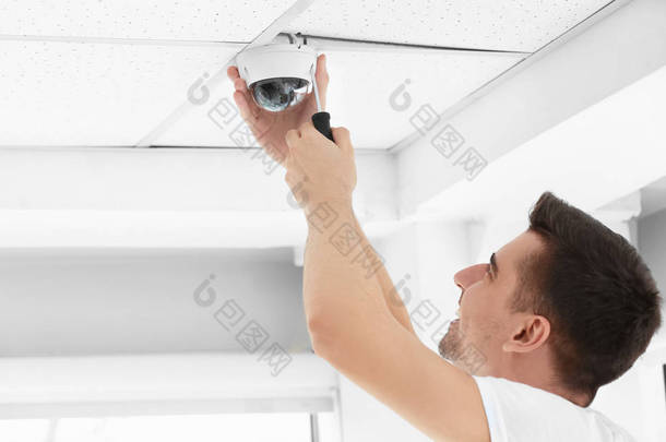 在室内天花板上安装<strong>cctv</strong>摄像头的技师