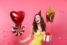 快乐的年轻女子气球和礼品盒摆在粉红色背景