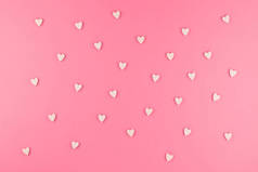情人节模式背景平躺在粉红色的心形糖果的顶部视图散落在粉色背景上爱情婚礼理念