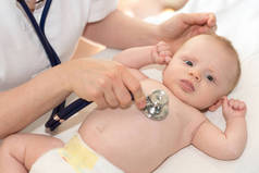 儿科医生用听诊器检查小婴儿的手