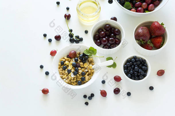 带草莓, 蓝莓, 樱桃, 醋栗, 黑醋栗和蜂蜜的自制燕麦碗白色木质背景。顶部视图。平躺。复制空间