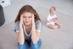 年轻母亲患有产后抑郁症和小婴儿在房间里