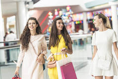 微笑时尚的年轻女性手持纸袋和步行在购物中心