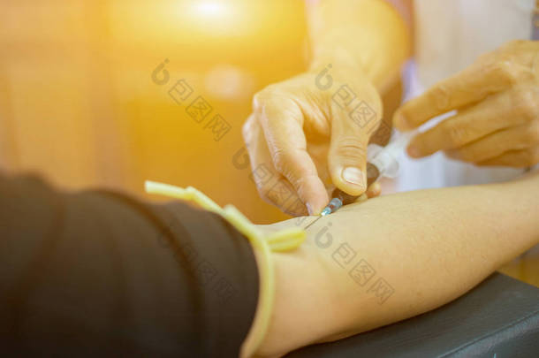 从<strong>病人</strong>身上抽取血样的<strong>护士</strong>手里的注射器
