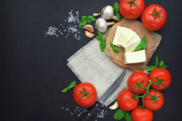 奶酪, 罗勒和西红柿木板, 复制空间。卡普雷塞沙拉和希腊沙拉的配料。顶部视图。平躺。深色木制背景