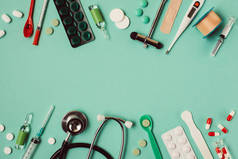 绿色背景的各种医疗药丸和器械的平铺