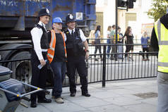 伦敦, 英国-2018年9月14日: 警察在市中心与一名工人合影.