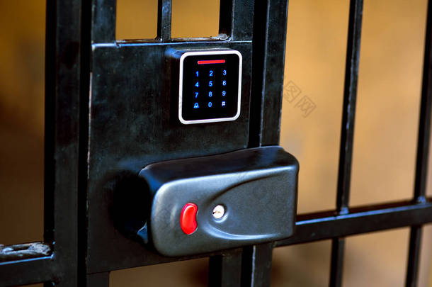 铁门上的锁, 钥匙有一个洞, 还有一个触摸屏, 用来进入进入钥匙或密码打开入口.