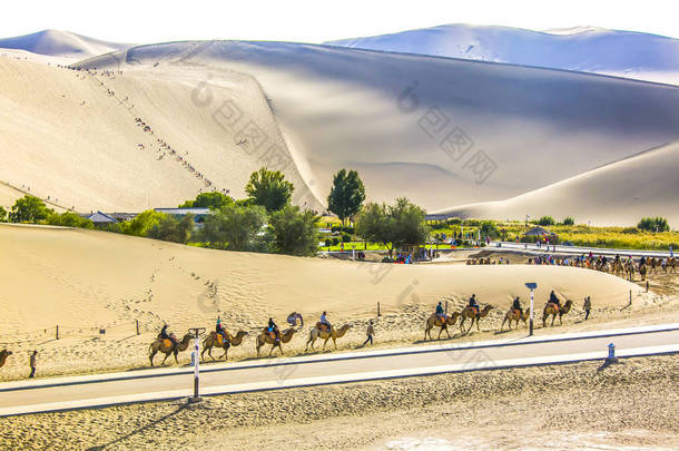 2018年9月17日, 在月牙湖 (岳岩) 戈壁沙漠和甘肃省西北部敦煌的歌唱沙山风景区骑骆驼的游客
