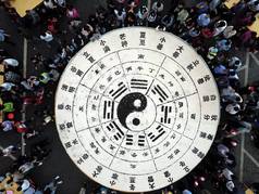 Tourists share 3.5 tons of tofu in the shape of a Tai Chi diagram during a Taoist festival at the La