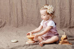 玩木制玩具金字塔的儿童女孩。可爱的小女孩与自然玩具。复制空间