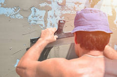 五十岁的手工工人用墙抹灰工具翻新房子。泥水匠用刮刀和石膏翻新墙壁和角落。壁泥安装。建筑整理工程
