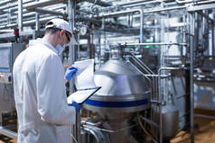 站在乳品厂生产部时, 技术人员做必要的笔记