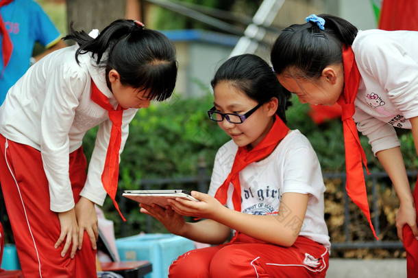 9月 2 9日, 在中国西北甘肃省兰州市一所小学的课间休息时, 一名戴眼镜的年轻中国<strong>近视眼</strong>女生在她的 ipad 平板电脑上玩着一个手机游戏