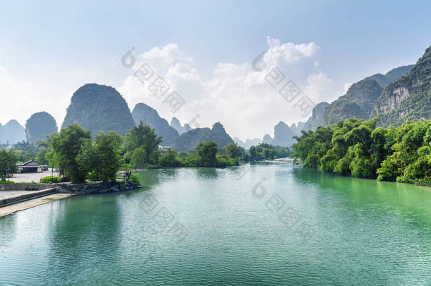 中国桂林阳朔县的玉龙河景色令人惊叹。在夏日的蓝天背景上可以看到美丽的喀斯特山脉。美妙的风景.