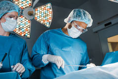 护士和外科医生在制服和医疗口罩做手术