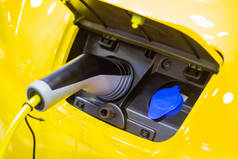 汽车新汽车的充电电池革新电源插在电动汽车上充电，能源创新的概念.
