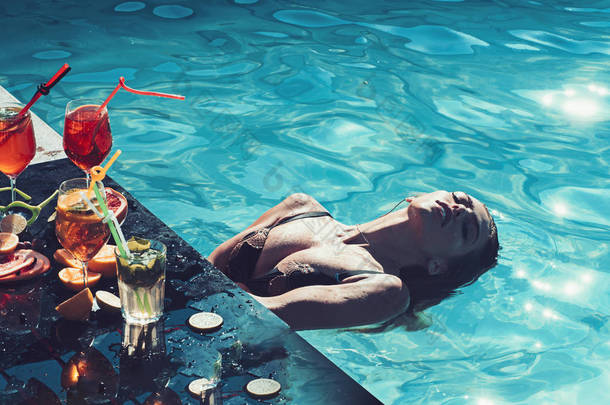 泳池派对可在水疗度假村放松身心。暑假和海上游泳。时尚的女人与刷新酒精在迈阿密。鸡尾酒与水果在性感的女孩在马尔代夫的游泳池。喝新鲜的维生素汁, 饮食.